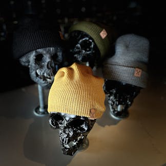 Photo of our beanies in all 4 colors: yellow, gray, black, and green.