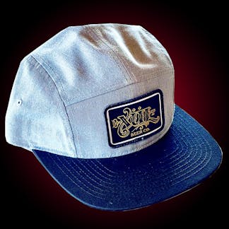 Five panel gray hat with our full logo in gold on a black woven patch