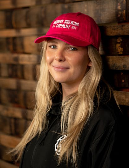Woman in red cap with "Bravery Brewing Company" embroidered in white on front