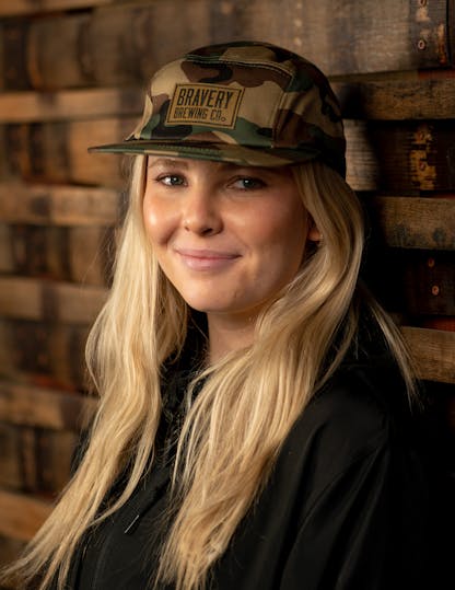 Woman in camouflage cap with leather Bravery Brewing logo patch