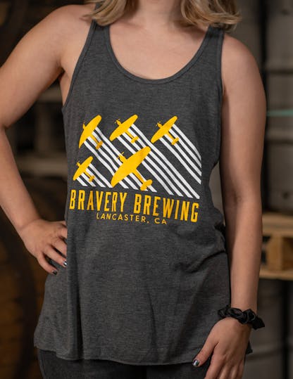 grey women's tank top with "Bravery Brewing Lancaster CA" written in yellow letters under a white and yellow airplane design