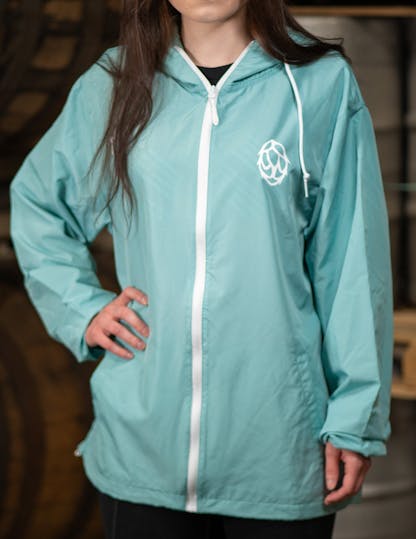 light blue windbreaker jacket with drawing of a hop flower in white on left side of chest