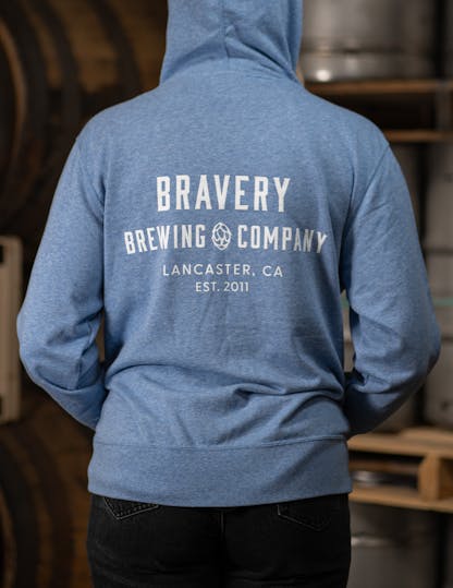 Light blue zip-up hoodie with large white text on the back reading, "Bravery Brewing Company, Lancaster CA, est. 2011"