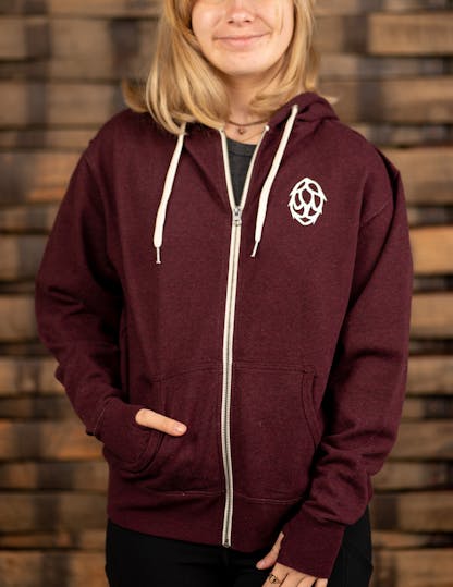 dark red zip-up hoodie with white hop on the front left side