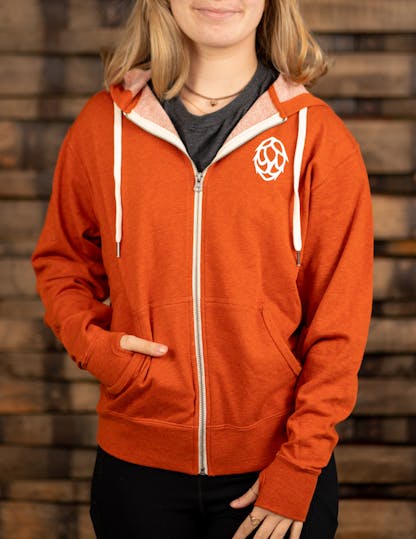 orange zip-up hoodie with white hop on the front left side