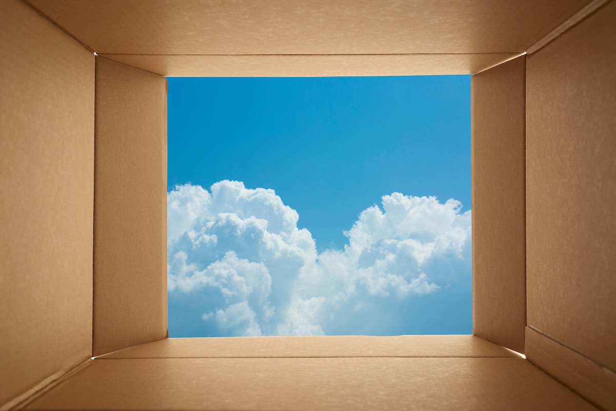 Looking,Though,Cardboard,Open,Box,Toward,Blue,Sky,Background.