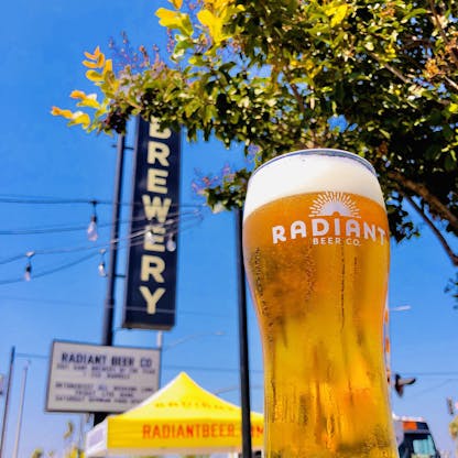 Radiant Beer Co pint glass in front of taproom 