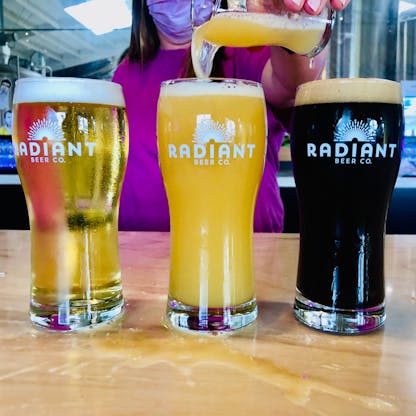 3 Radiant Beer Co pint glasses on a bar
