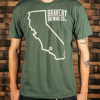 front of a green t-shirt. There is a large outline of the state of California with a star near the bottom of the state where Bravery is located. Next to the outline of the state is the text "Bravery Brewing Co." Both the illustration and text are printed in white ink.