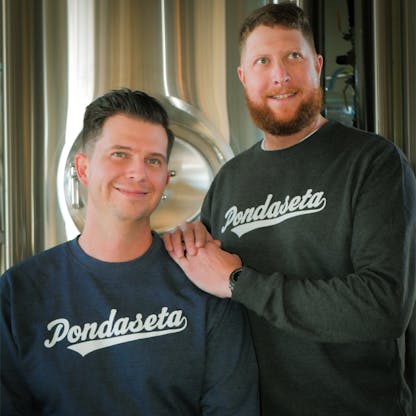 two men posing in pondaseta sweaters
