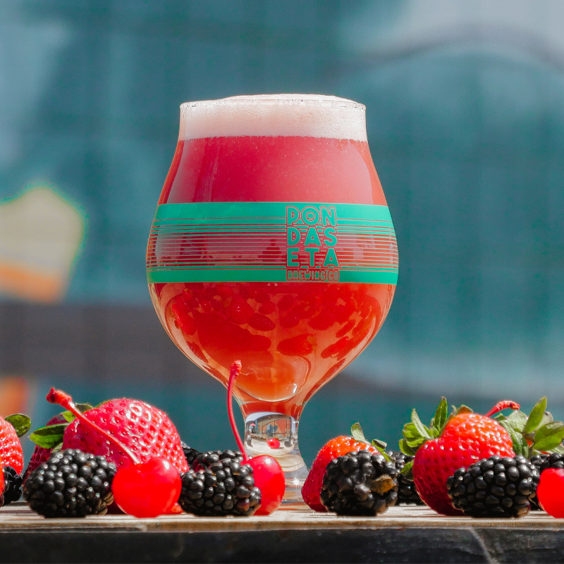 tulip with printed stripes full of red beer surrounded by berries