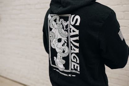 Black hoodie sweatshirt with large white Savage Craft logo on back
