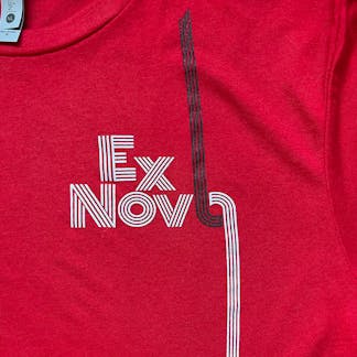 close up of white and black logo on red t-shirt with text "Ex Novo"