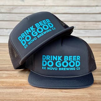 two gray foam baseball hats with mesh backs stacked on a tabletop with teal bold text "Drink Beer Do Good" and smaller teal text "Ex Novo Brewing Co."