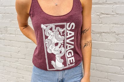 Women's racerback tank in maroon with large Savage Craft logo on front in white