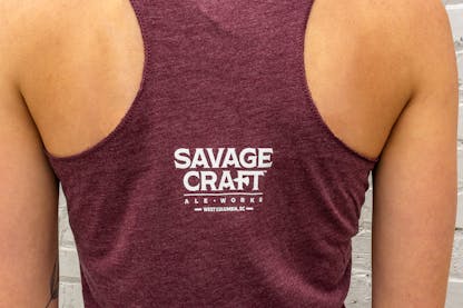 Women's racerback tank in maroon with small Savage Craft logo on the center back