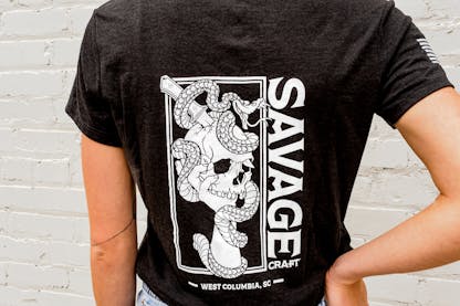 Women's black short sleeve v-neck shirt with large white Savage Craft logo on the back