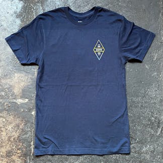 navy t-shirt on concrete floor, front view with small diamond shaped logo on front chest stacked text "Ex Novo OR"