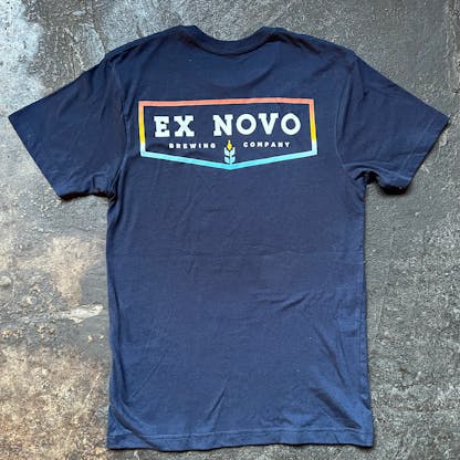 navy t-shirt on concrete floor, back view with large chevron shaped logo text "Ex Novo Brewing Company"
