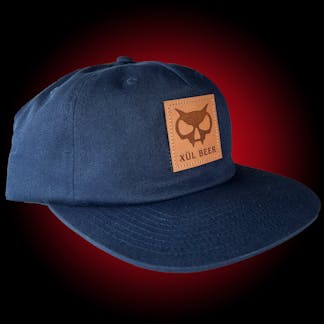 pinch-front 5 panel navy hat with fanghead on leather patch