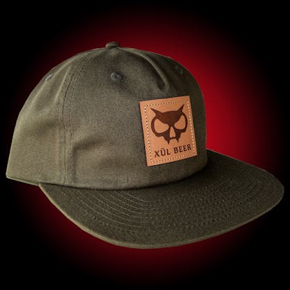 Pinch-front olive 5-panel hat with fanghead logo on a leather patch. Leather strapback.