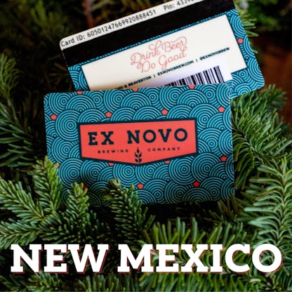 two gift cards nestled amidst evergreen boughs, front features red chevron logo with black outline text "Ex Novo Brewing Company" and repetitive design of swirl concentric circles in black with red dots interspersed. in back is reverse side of gift card with partial glimpse of bar code, black swipe stripe, yellow box with text "Drink Beer Do Good" and along top text "Card ID" followed by 16 digits and out of focus text "Pin" with illegible numbers following; white overlay text at base of image "New Mexico"