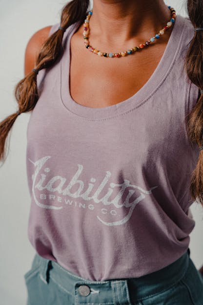 woman wearing a lavender tank top with Liability Brewing