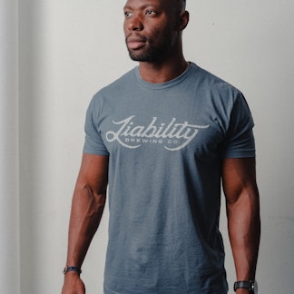 man wearing an indigo shirt with Liability Brewing