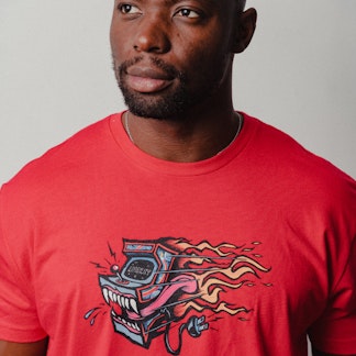 man wearing red shirt with multicolored arcade machine