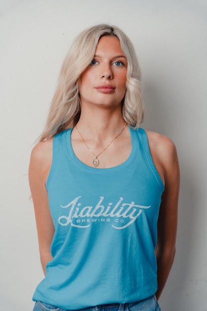 woman wearing a turquoise tank top with Liability Brewing
