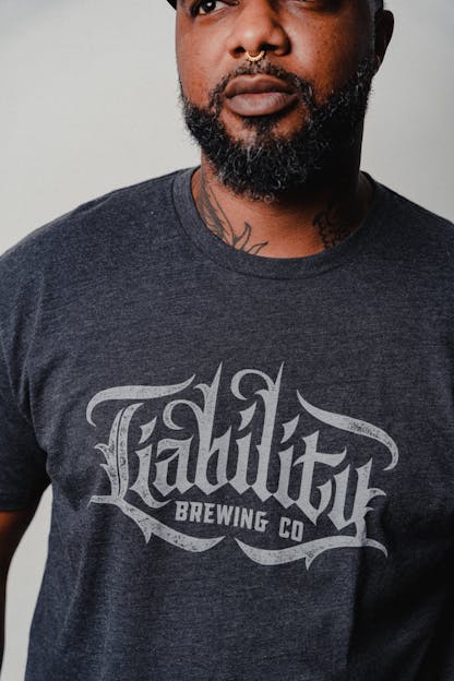 man wearing charcoal shirt with Liability Brewing