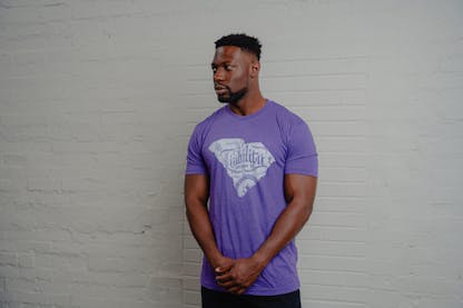 man wearing purple shirt with SC state logo