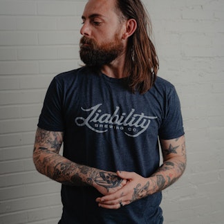 man wearing a charcoal shirt with Liability Brewing