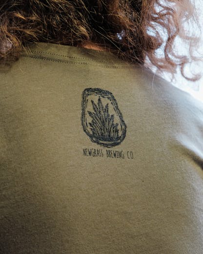 Back of army green T-shirt with small Newgrass Brewing terrarium logo in black 