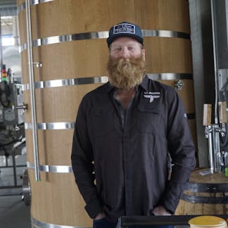 Male wearing copper black long sleeve standing in front of a Foeder