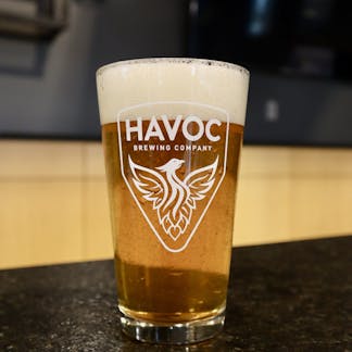 Clear pint glass with white Havoc logo.