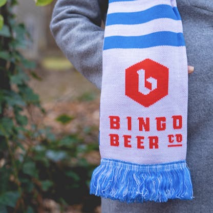 A woven scarf with the bingo logo on it being worn outside