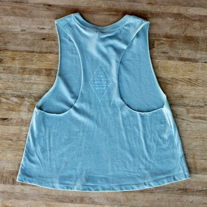 back side of denim wash racerback light blue tank top with diamond graphic saying EX NOVO BREW in a light blue ink