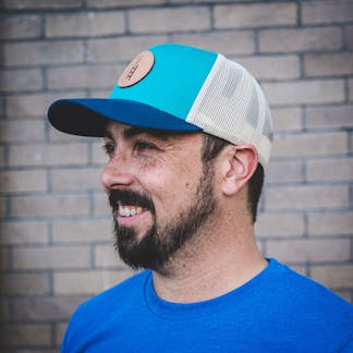 Teal & Blue Trucker Hat with adjustable strap featuring leather debossed Corporate Ladder Logo.