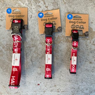three red dog collars on brown cardboard square tags on a gray background