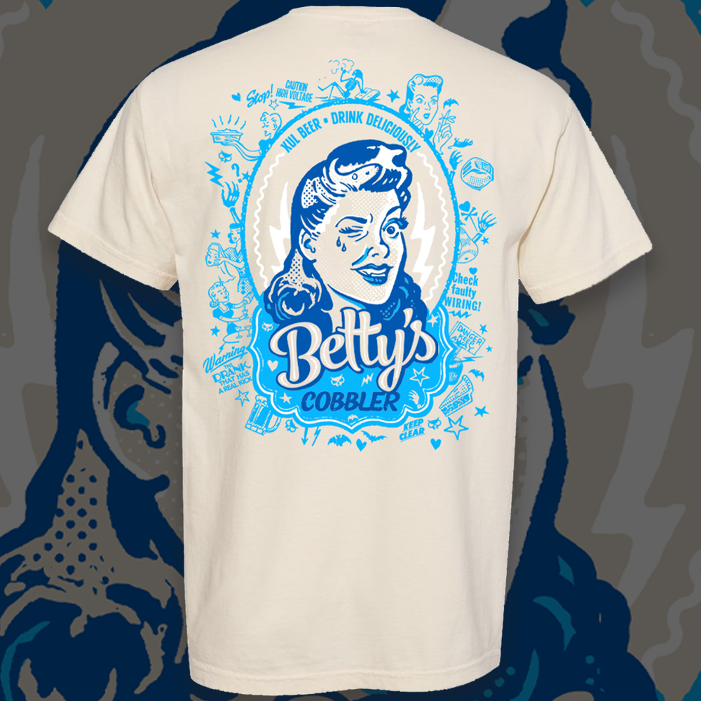 Comfort Colors tan shirt with our Betty's Cobbler can art on the back in light and dark blues.