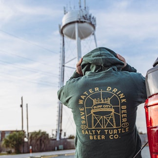 Green Hoodie in front of Surf City Water Tower
