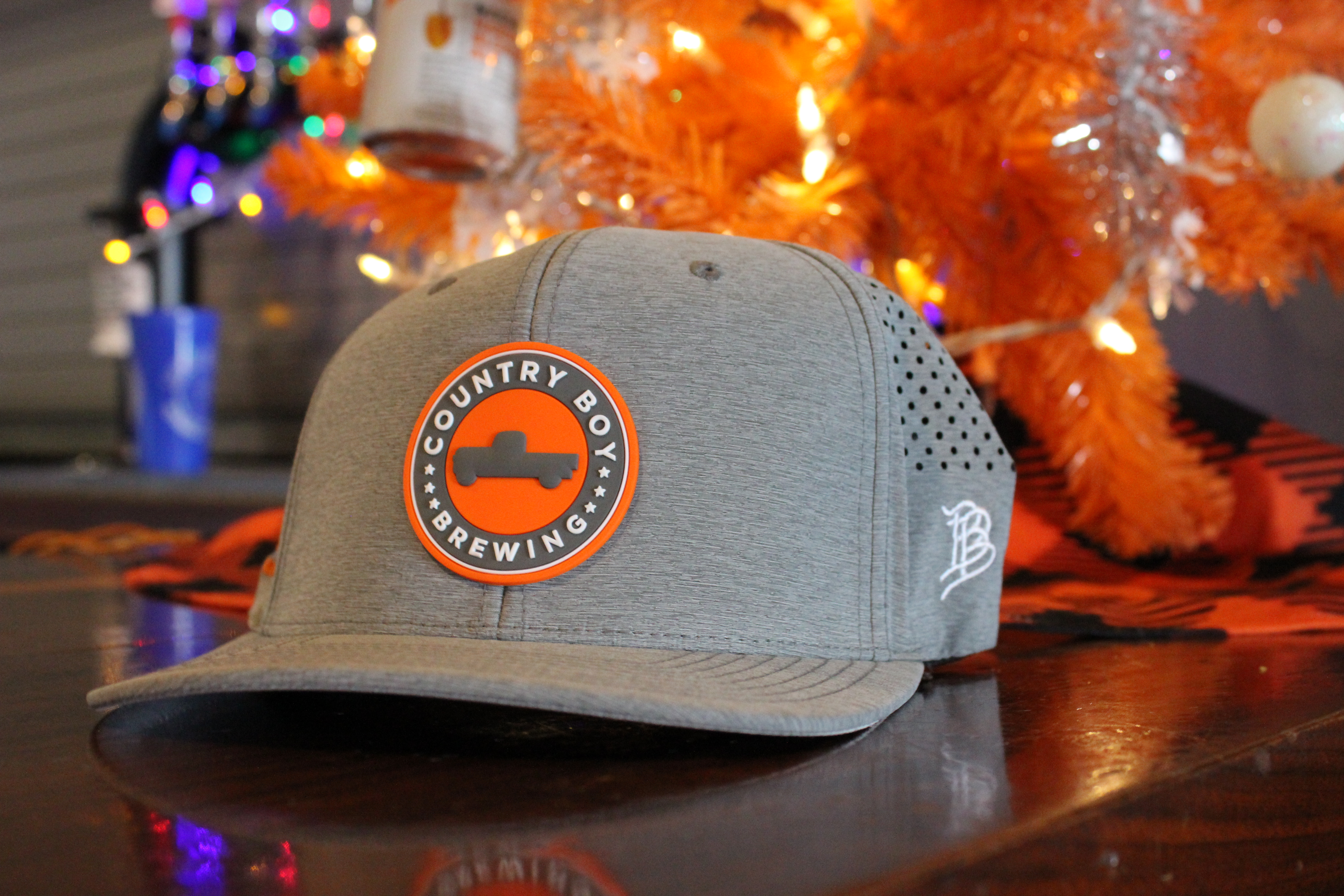 Branded Bills Gray Hat with Orange Country Boy Brewing logo circle patch in front.