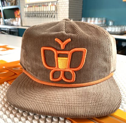 Orange butterfly on brown corduroy hat