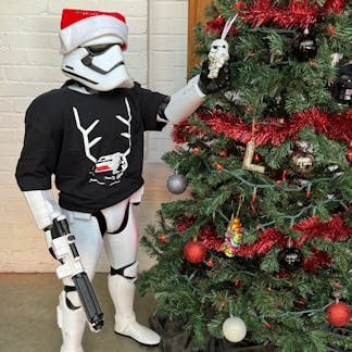 stormtrooper modeling shirt in front of christmas tree