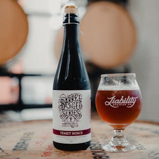draft and bottle on barrel in taproom