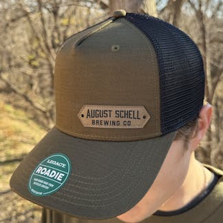 Olive green baseball hat with Schell patch on front.