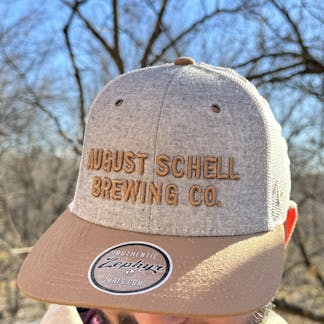 Grey, white and brown baseball hat with Schell embroidered on front.