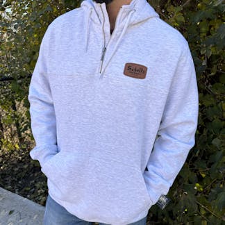 Silver colored quarter zip hood with Schell patch.