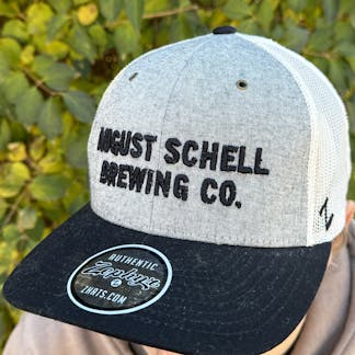 Black, grey and white baseball hat with Schell embroidered on front in black.